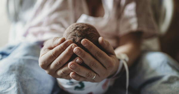 Mulher segurando a cabeça do bebê com as mãos