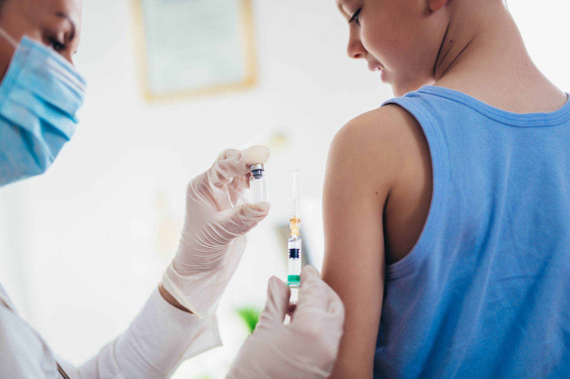 Menino sendo vacinado por médica