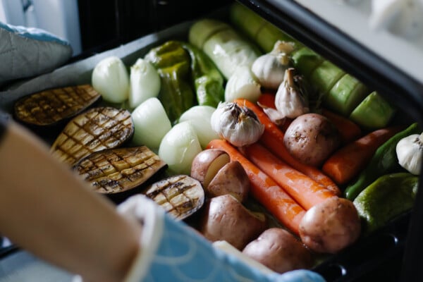 Bandeja servida com berinjela, cebola, alho, batatas, cenoura e outros vegetais e legumes