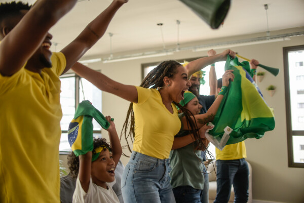 Família reunida na sala comemorando durante um jogo do Brasil