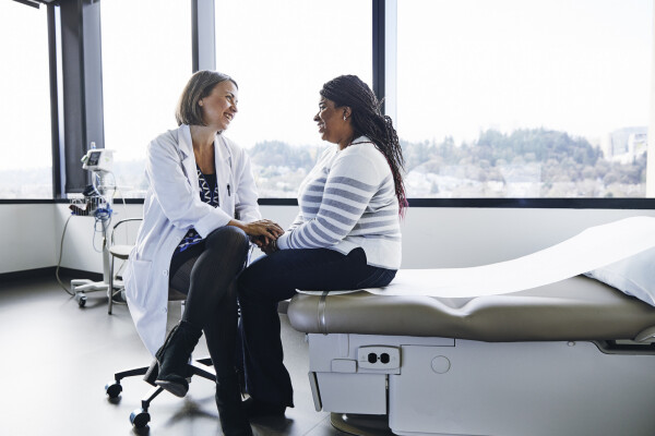 Médica conversando com paciente mulher em consultório