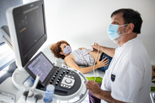 Grávida fazendo ultrassonografia com máscara