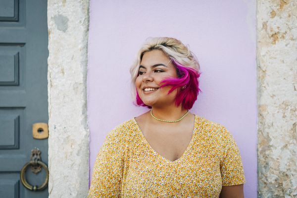 Mulher sorridente com mechas rosas