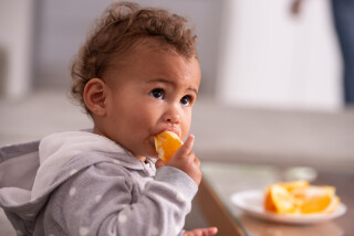 Criança comendo laranjas