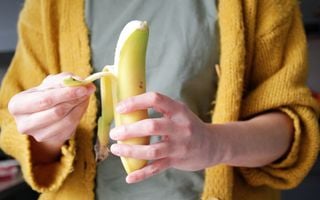 Mulher descascando uma banana