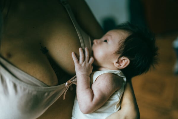 Mulher amamentando bebê enquanto usa um sutiã de amamentação