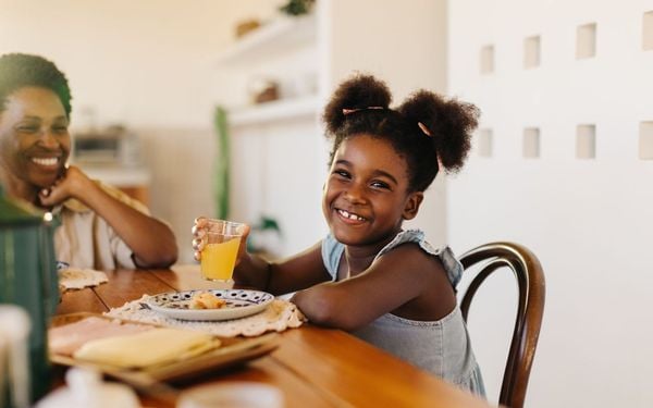 criança tomando café com a família