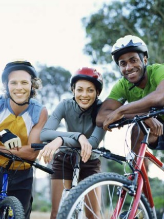 Dois homens e uma mulher equipados para andar de bicicleta