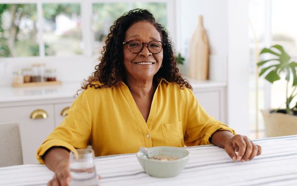 mulher com 60 anos tomando café da manhã