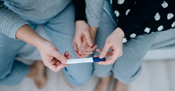 Casal segurando um teste de gravidez
