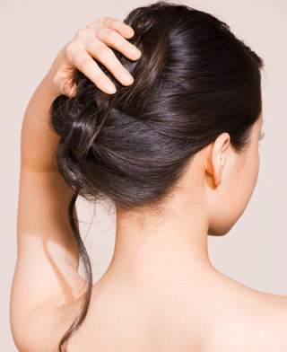 mulher segurando os cabelo em forma de coque - Foto Getty Images