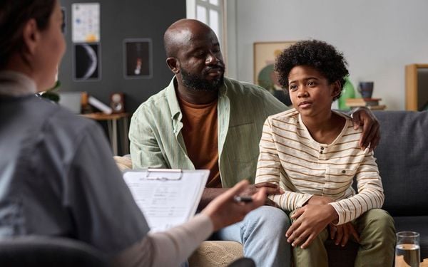 Psicoterapeuta atende uma criança negra de aproximadamente 10 anos