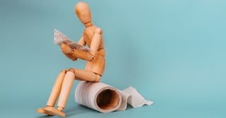 boneco sentado em um rolo de papel higiênico