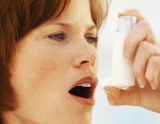 mulher segurando uma bombinha de asma