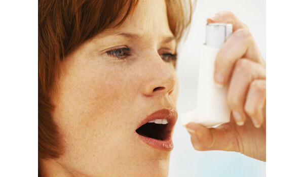 mulher segurando uma bombinha de asma