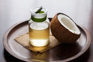 óleo de coco e um coco em cima de uma mesa