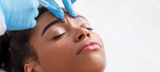 Mulher negra recebe aplicação de toxina botulínica na testa, conhecida por botox