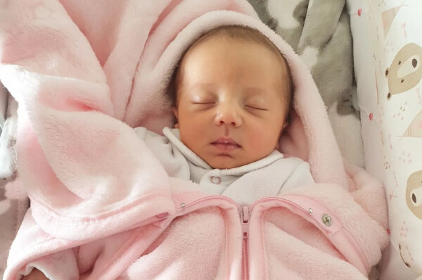 Bebê dormindo usando um cobertor rosa