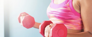 Mulher de top fazendo exercício com halteres rosas