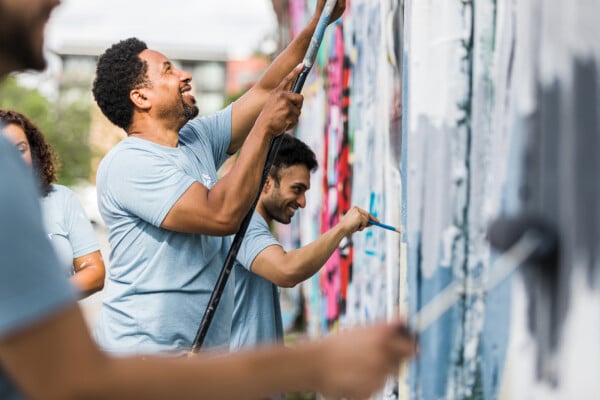 Homens voluntários pintando parede