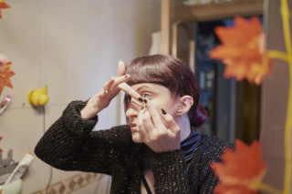 Mulher colocando as lentes de contato no banheiro olhando para o espelho