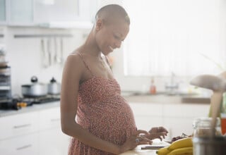 Mulher grávida de 8 meses cozinhando