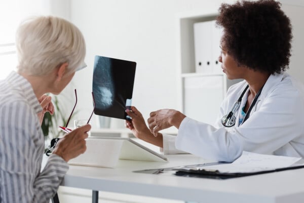 Médica analisando resultado de mamografia com paciente