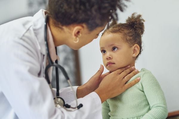 Médica examinando a garganta de criança