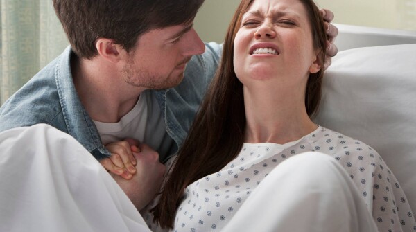 Mulher com dor durante o parto ao lado do companheiro