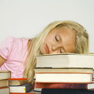 Criança dormindo em cima dos livros - Foto: Getty Images