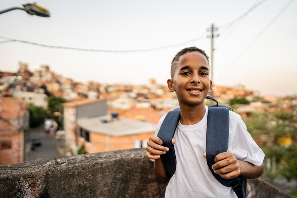Criança sorridente com mochila nas costas