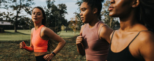 Três mulheres em um parque correndo e praticando exercícios