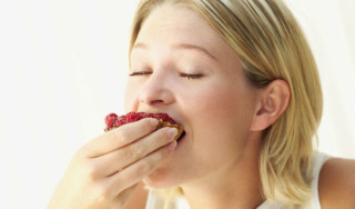 Moça comendo um doce - Foto: Getty Images