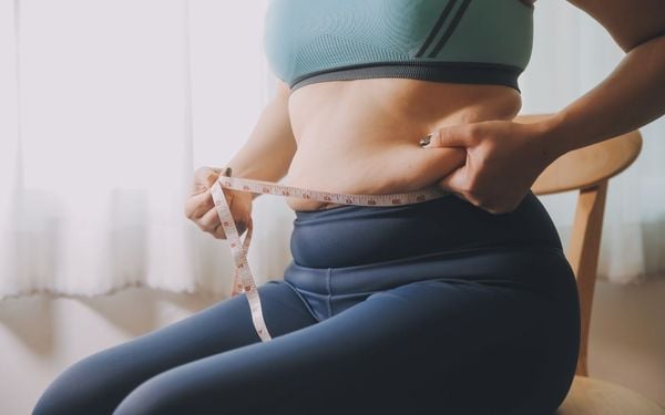 mulher medindo a barriga com fita métrica