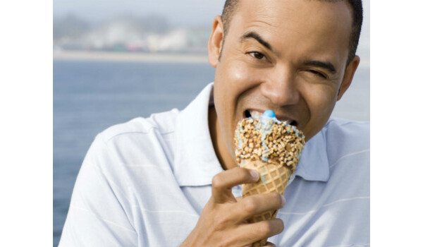 Homem com dentes sensíveis comendo sorvete