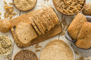 Mesa posta com pães, massas e grãos integrais