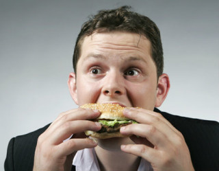 homem comendo hambúrguer