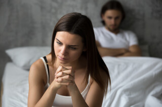 Mulher triste frustrada sentada na cama pensando em problemas de relacionamento, casal pensativo