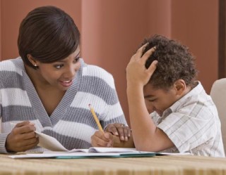 criança fazendo lição de casa com ajuda da mãe