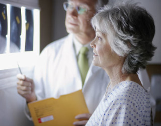 Médico e mulher olhando radiografia