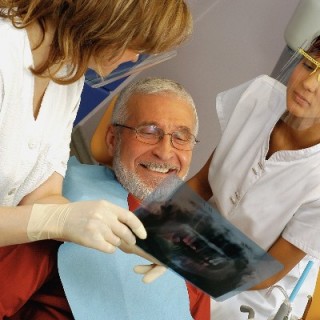 Dentista mostrando exame para paciente homem