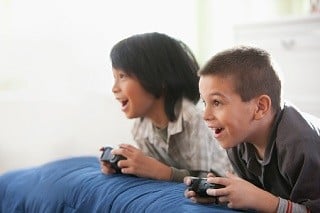 Meninos jogando videogame juntos - foto: Getty Images
