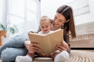 mãe lendo livro para bebê