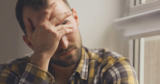 Homem com dor de cabeça causada pela crise de ansiedade