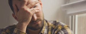 Homem com dor de cabeça causada pela crise de ansiedade