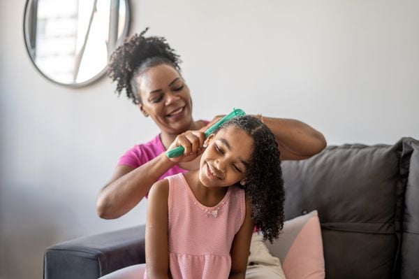 Mãe penteando o cabelo da filha