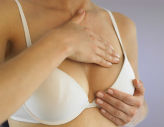 Mulher fazendo autoexame para o câncer de mama 