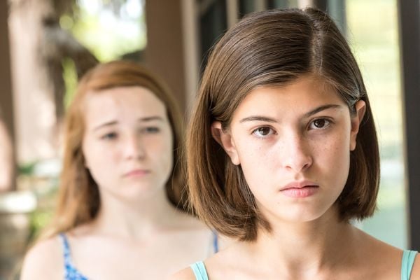 Menina ignorando outra menina que está atrás dela