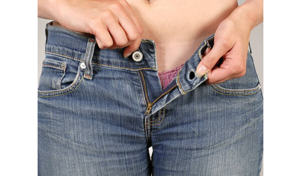 mulher abrindo a calça jeans