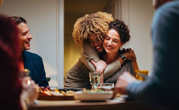 Amigas se abraçando durante jantar